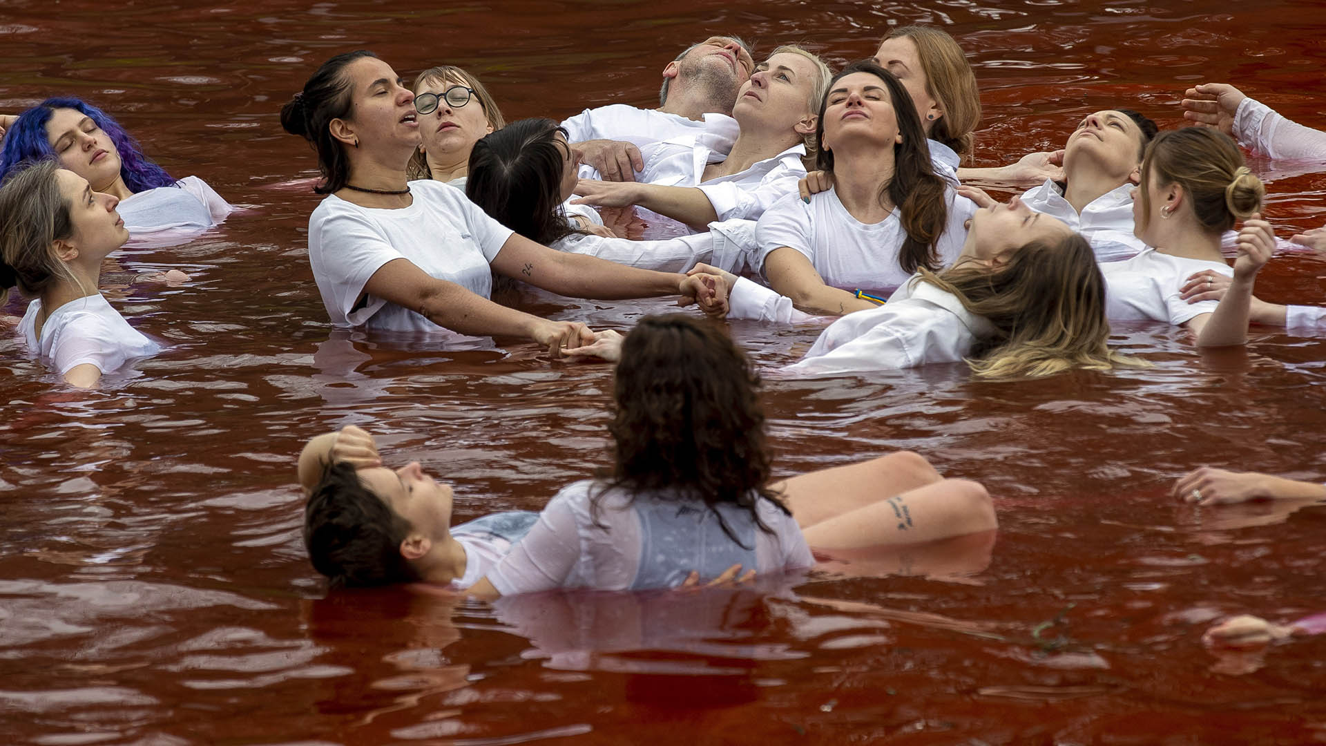 Pacifisti nuotano in un lago rosso sangue a Vilnius davanti Ambasciata Russia