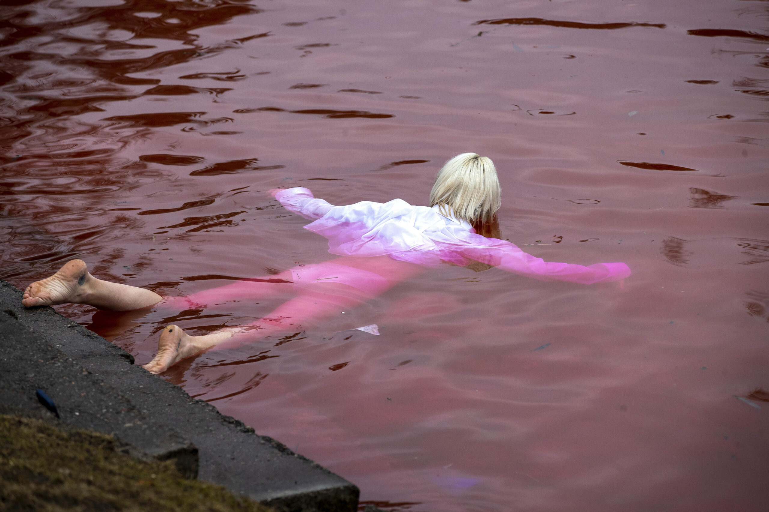 Pacifisti nuotano in un lago rosso sangue a Vilnius davanti Ambasciata Russia