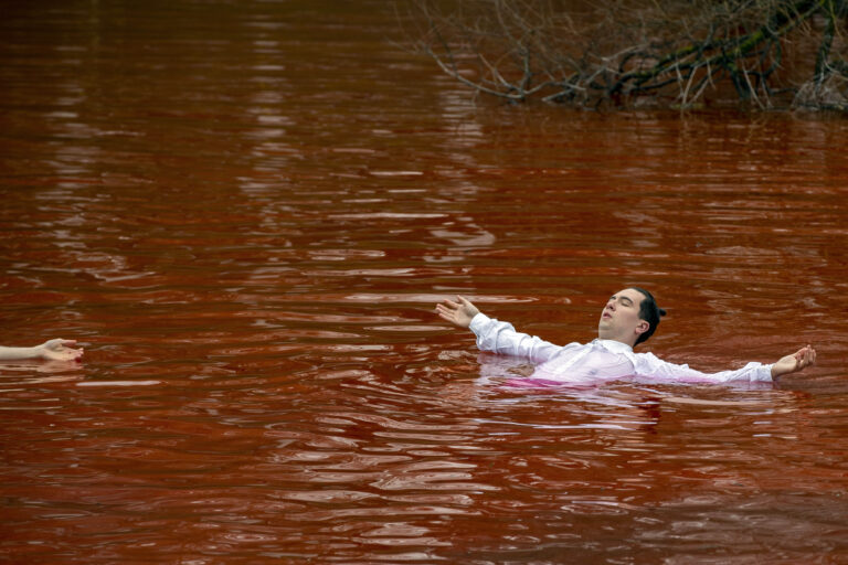 Pacifisti nuotano in un lago rosso sangue a Vilnius davanti Ambasciata Russia