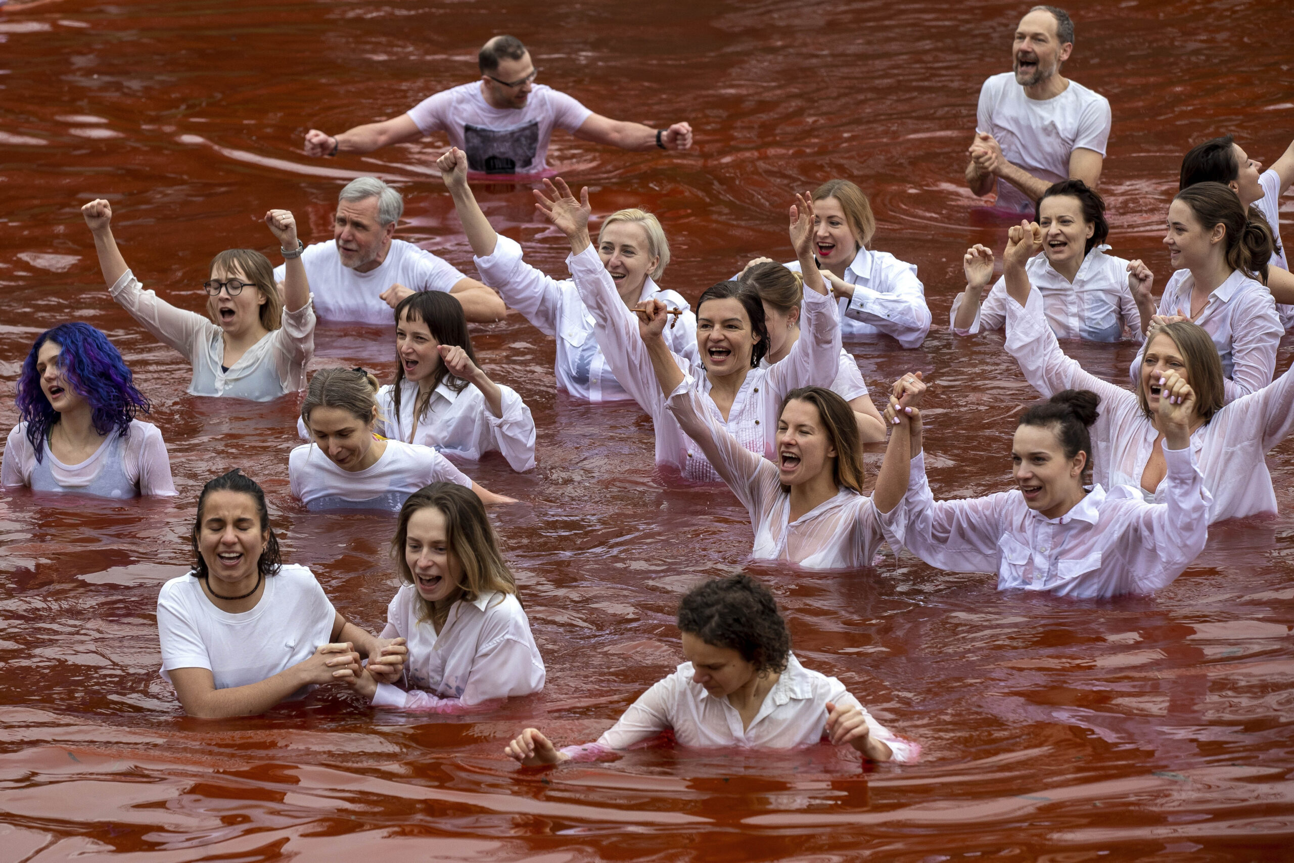 Pacifisti nuotano in un lago rosso sangue a Vilnius davanti Ambasciata Russia