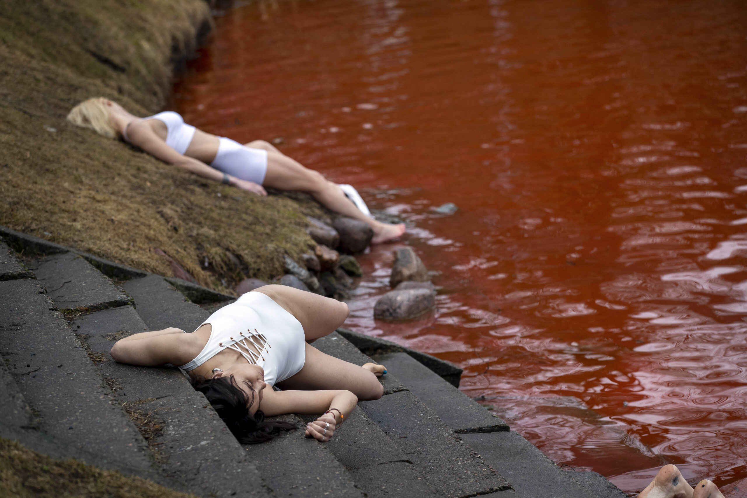 Pacifisti nuotano in un lago rosso sangue a Vilnius davanti Ambasciata Russia