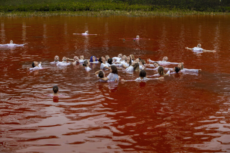 Pacifisti nuotano in un lago rosso sangue a Vilnius davanti Ambasciata Russia